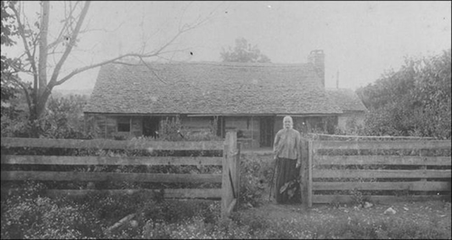 Photograph of Morton farm circa 1911 with Nancy Morton standing in front.